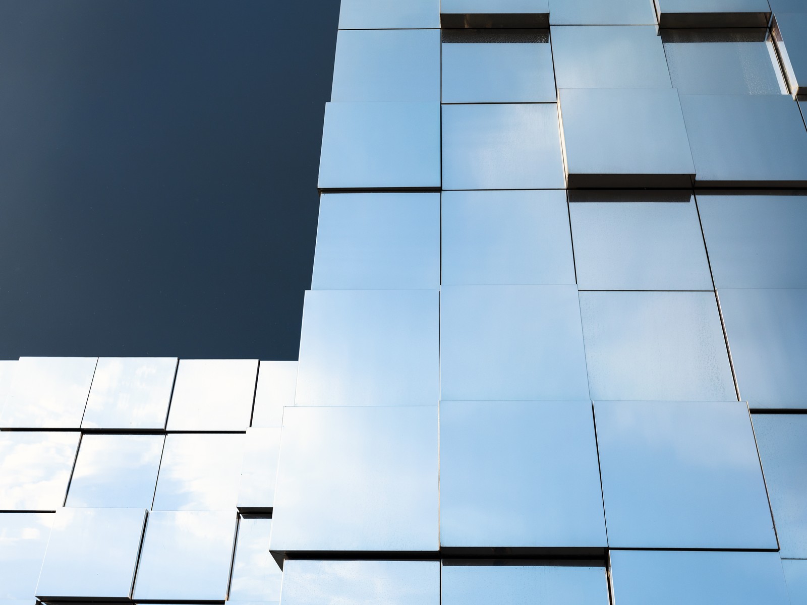 Facciata di un edificio contemporaneo rivestita in pannelli di vetro riflettente